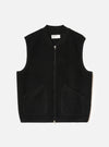 Black Wool Fleece Zip Waistcoat laid flat on a light grey studio backdrop. Features a V-neckline, full front zip closure, two lower patch pockets, and tonal binding along the neck, armholes, and hem. No model or mannequin present.