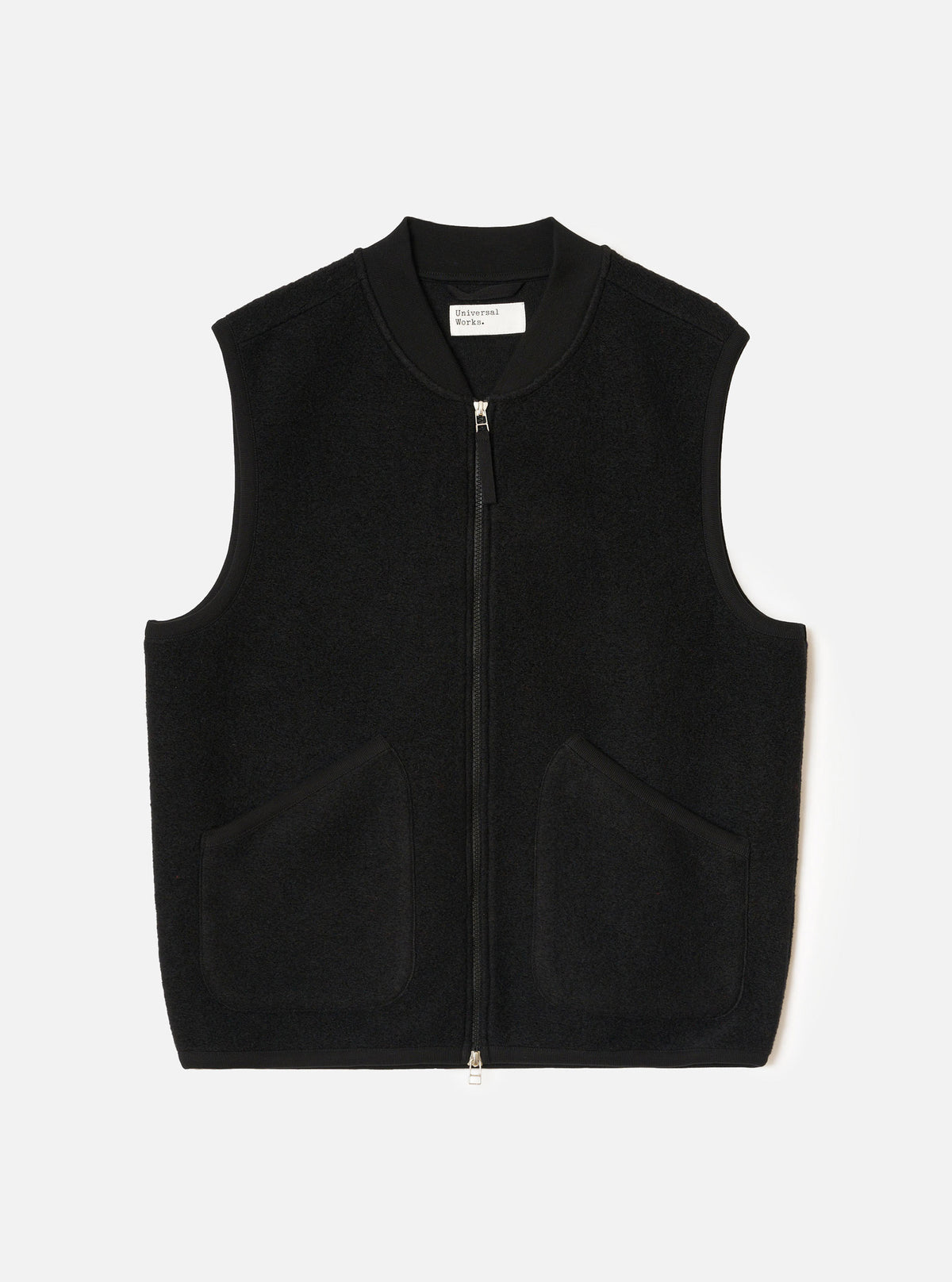 Black Wool Fleece Zip Waistcoat laid flat on a light grey studio backdrop. Features a V-neckline, full front zip closure, two lower patch pockets, and tonal binding along the neck, armholes, and hem. No model or mannequin present.