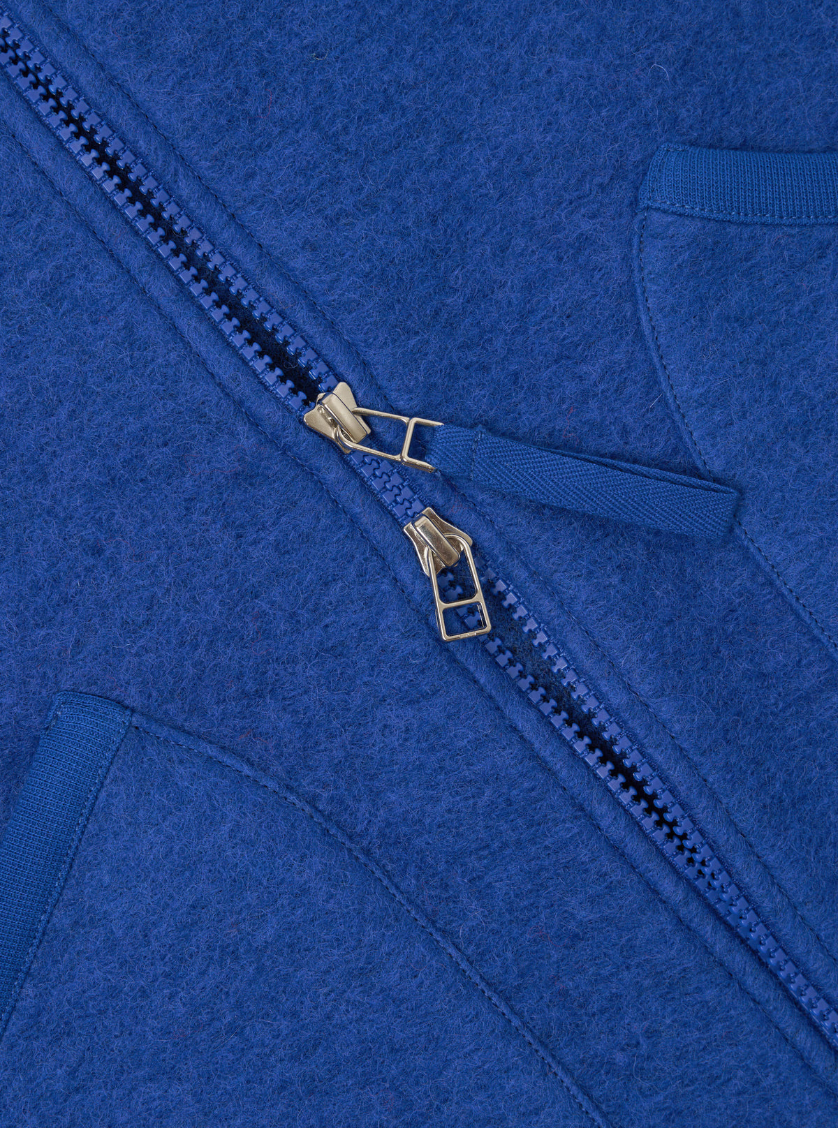Rear view of the Universal Works Blue Wool Fleece Zip Waistcoat displayed on a clean white background. Highlights include the soft blue wool fleece texture, flat hemline, precise back seams, and jersey-bound armholes.