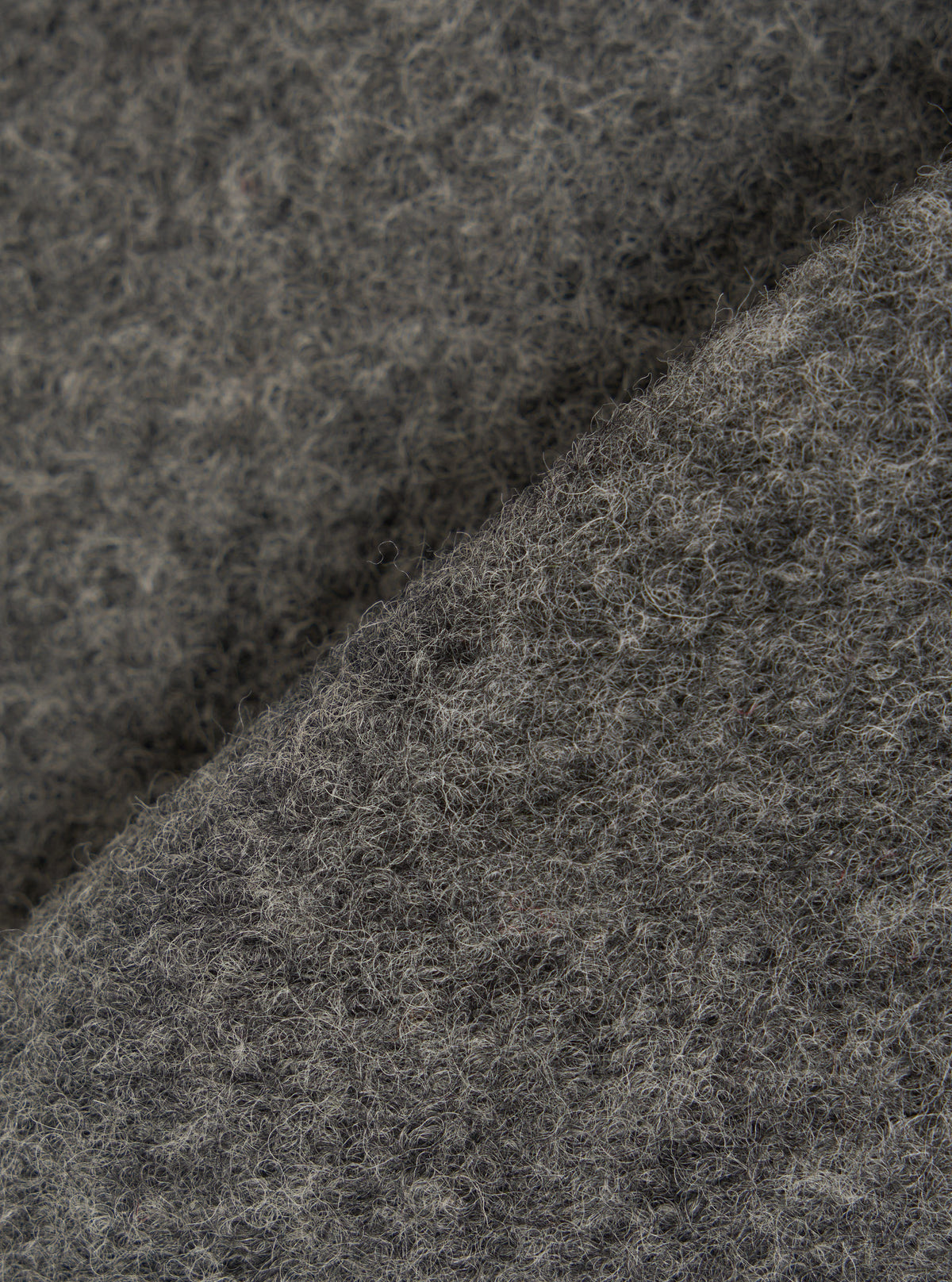 Extreme close-up fabric swatch image showcasing the texture of the Grey Marl Wool Fleece Zip Waistcoat. The detailed shot highlights the rich grey marl tone, soft fibers, and cozy tactile feel of the wool fleece material.