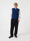 Front view of a model wearing the Indigo Wool Fleece Zip Waistcoat layered over a top in a studio setting with a light backdrop. The model stands facing forward, showing how the indigo fleece waistcoat fits.