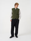Front view of a model wearing the Olive Wool Fleece Zip Waistcoat in a studio setting. The model stands facing forward, showing how the green olive fleece waistcoat fits when layered over a garment.