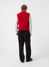 Side angled view of a model wearing the Scarlet Wool Fleece Zip Waistcoat in a plain studio. The image highlights the fit, armhole design, and soft red wool fleece texture from an alternate perspective.