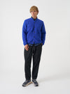 Front view of a model wearing the Blue Wool Fleece Cardigan in a studio setting with a plain light backdrop. The model stands facing forward, showing the blue wool fleece, V-neck, and button front.