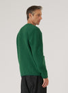 Profile shot of a model wearing a Green Wool Fleece Cardigan. The background is a plain white. The cardigan is a vibrant green and appears soft and warm.
