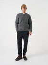 Front view of a model wearing the Grey Marl Wool Fleece Cardigan in a plain studio setting. The model stands facing forward, showcasing the grey heathered wool fleece, V-neckline, and five-button closure.