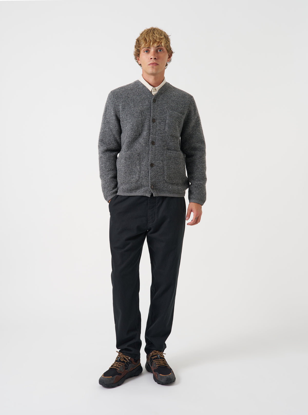 Front view of a model wearing the Grey Marl Wool Fleece Cardigan in a plain studio setting. The model stands facing forward, showcasing the grey heathered wool fleece, V-neckline, and five-button closure.