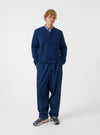 Front view of a model wearing the Indigo Wool Fleece Cardigan in a studio setting with a simple backdrop. The model stands facing forward, displaying the deep blue tone, V-neck collar, and front button closure.