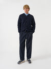 Front view of a model wearing the Navy Wool Fleece Cardigan in a studio setting with a light backdrop. The model stands facing forward, showcasing the classic dark navy shade, button front, and patch pockets.