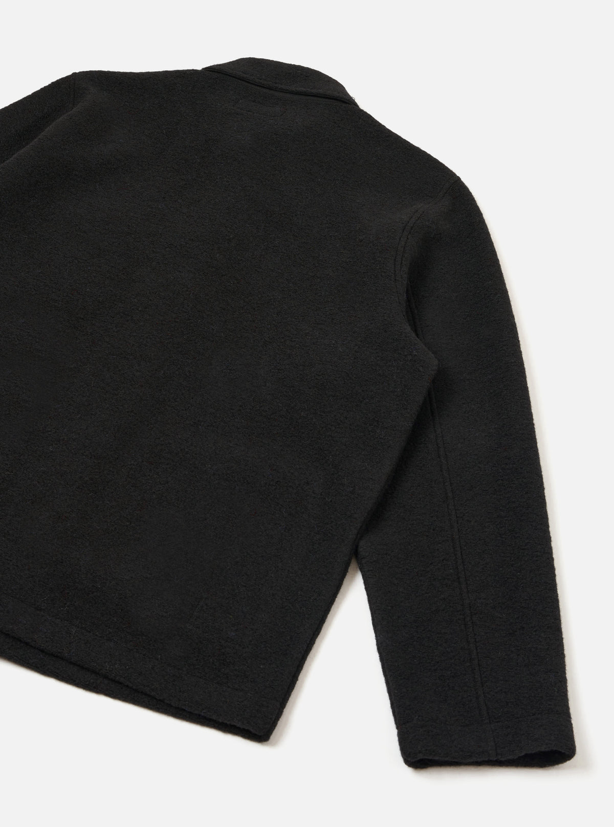 Rear view of the Black Wool Fleece Field Jacket presented on a plain white background. Showcases the clean back panel, straight hem, set-in sleeves, and rich black textured wool fleece material.