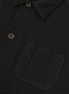 Detailed close-up shot of the Black Wool Fleece Field Jacket against a plain white background, highlighting the front chest pocket details, button fastenings, and soft wool fleece fabric texture.