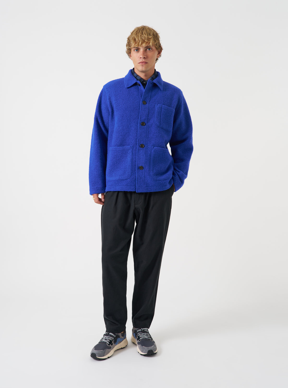 Front view of a model wearing the Blue Wool Fleece Field Jacket in a studio setting against a light background. The model stands facing forward, showing the blue fleece jacket's fit and styling.