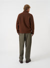 Angled rear view of a model wearing the Cacao Wool Fleece Field Jacket in a plain studio setting, showcasing the overall fit from the back and side in rich cacao brown wool fleece.