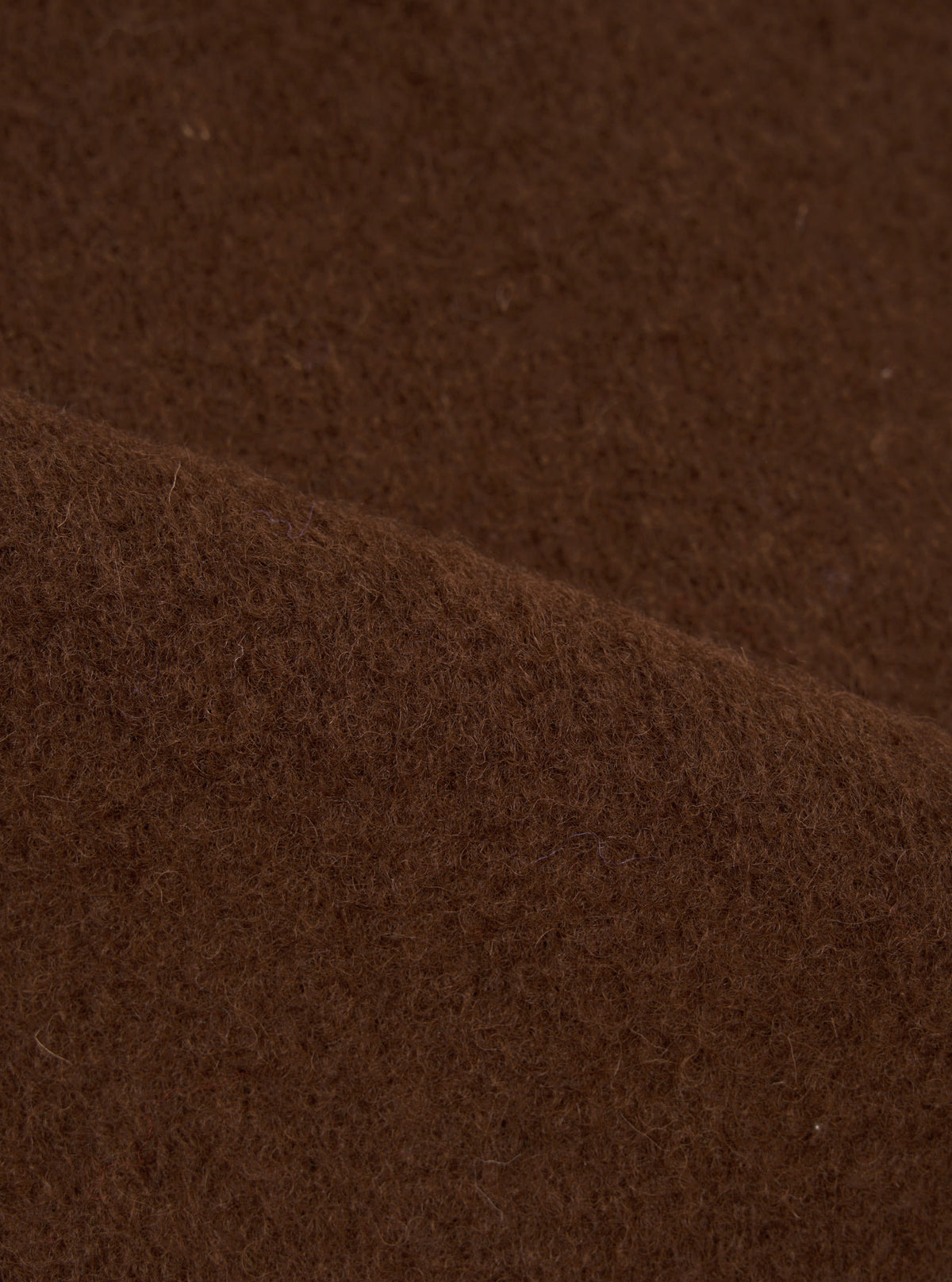 Extreme close-up fabric swatch image showcasing the texture of the Cacao Wool Fleece Field Jacket. The detailed shot highlights the soft cacao brown fibers and warm wool fleece feel.