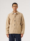 A model on a white background wears the Fawn Wool Fleece Field Jacket. The jacket is a light tan color and made of wool fleece. It has a relaxed fit.