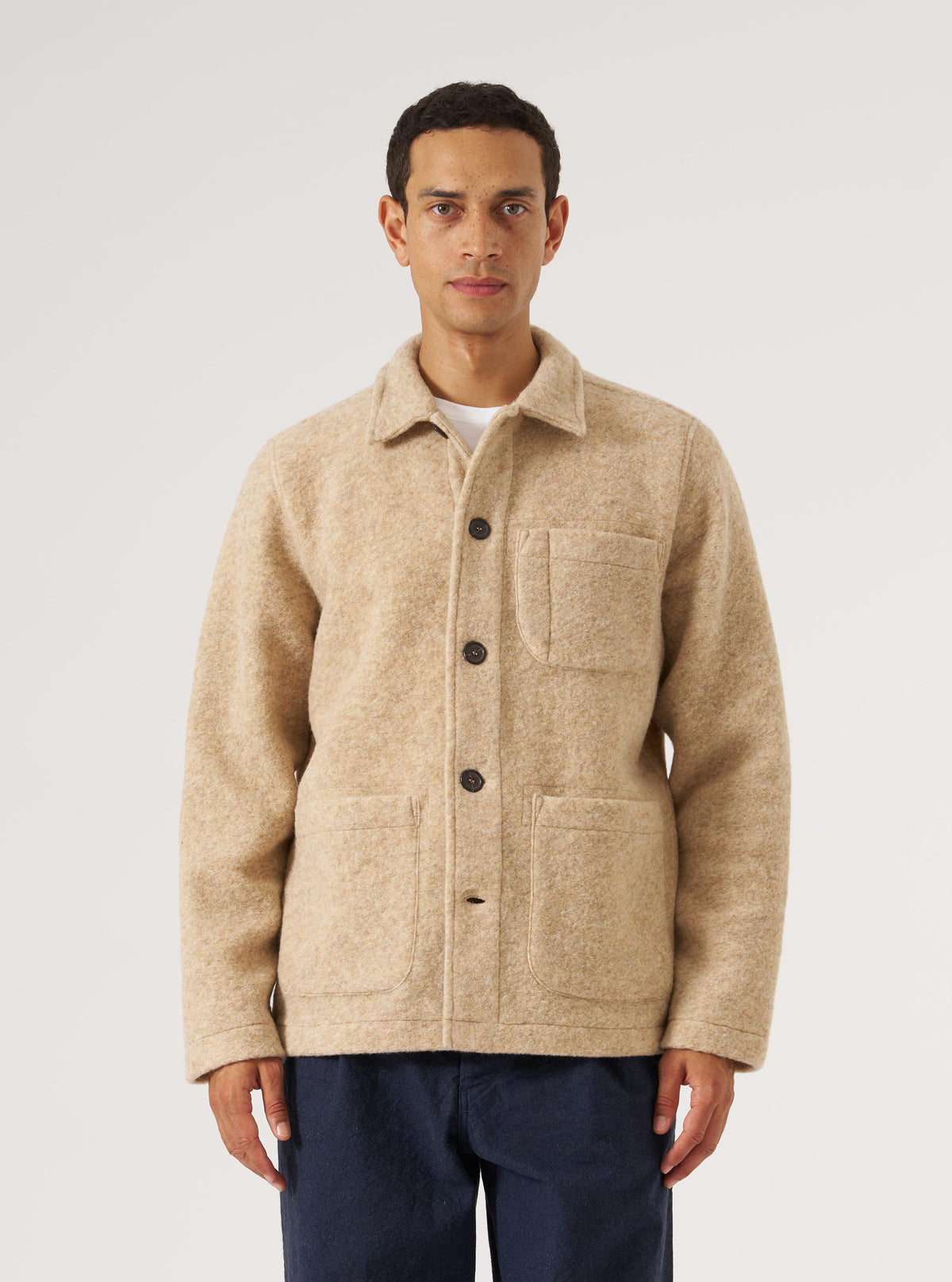 A model on a white background wears the Fawn Wool Fleece Field Jacket. The jacket is a light tan color and made of wool fleece. It has a relaxed fit.