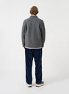 Angled side view of a model wearing the Grey Marl Wool Fleece Field Jacket in a studio backdrop. The shot demonstrates the garment fit, showing long sleeves and soft grey marl fleece texture in detail.