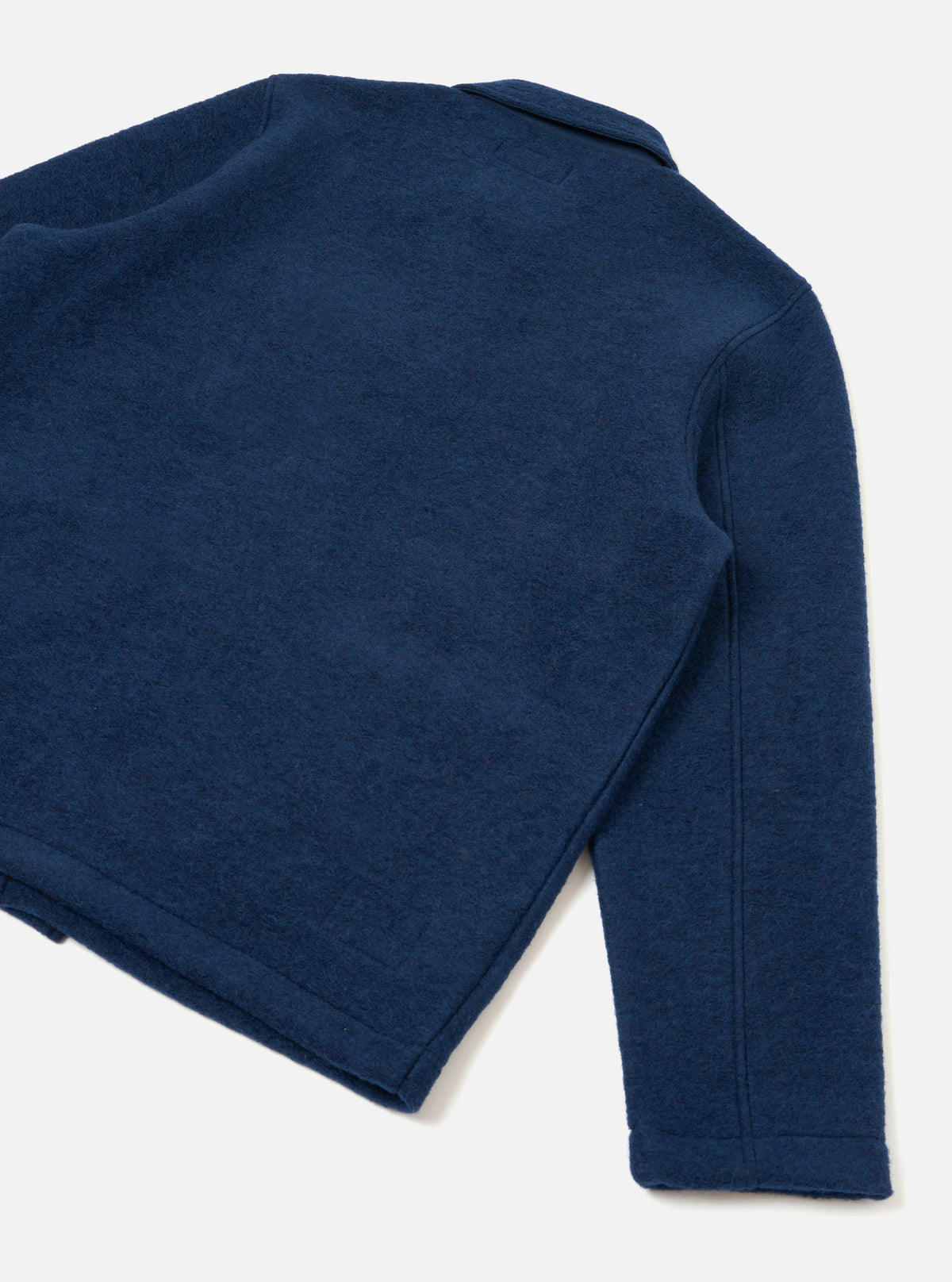 Rear view of the Indigo Wool Fleece Field Jacket presented against a plain white background. Highlights the soft deep blue fleece fabric, clean back paneling, straight hemline, and full sleeve construction.