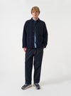 Front view of a model wearing the Navy Wool Fleece Field Jacket standing in a clean studio setting. The model faces forward, illustrating the dark navy garment fit, sleeve length, and button front.
