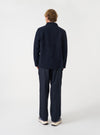 Angled view of a model wearing the Navy Wool Fleece Field Jacket in a minimalist studio environment. Highlights the casual fit, side profile, and rich navy wool fleece texture of the jacket.