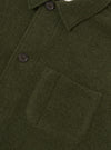 Side view of the Olive Wool Fleece Field Jacket displayed against a plain background. The olive green wool fleece fabric, structured jacket cut, chest pockets, and button placket are clearly visible.