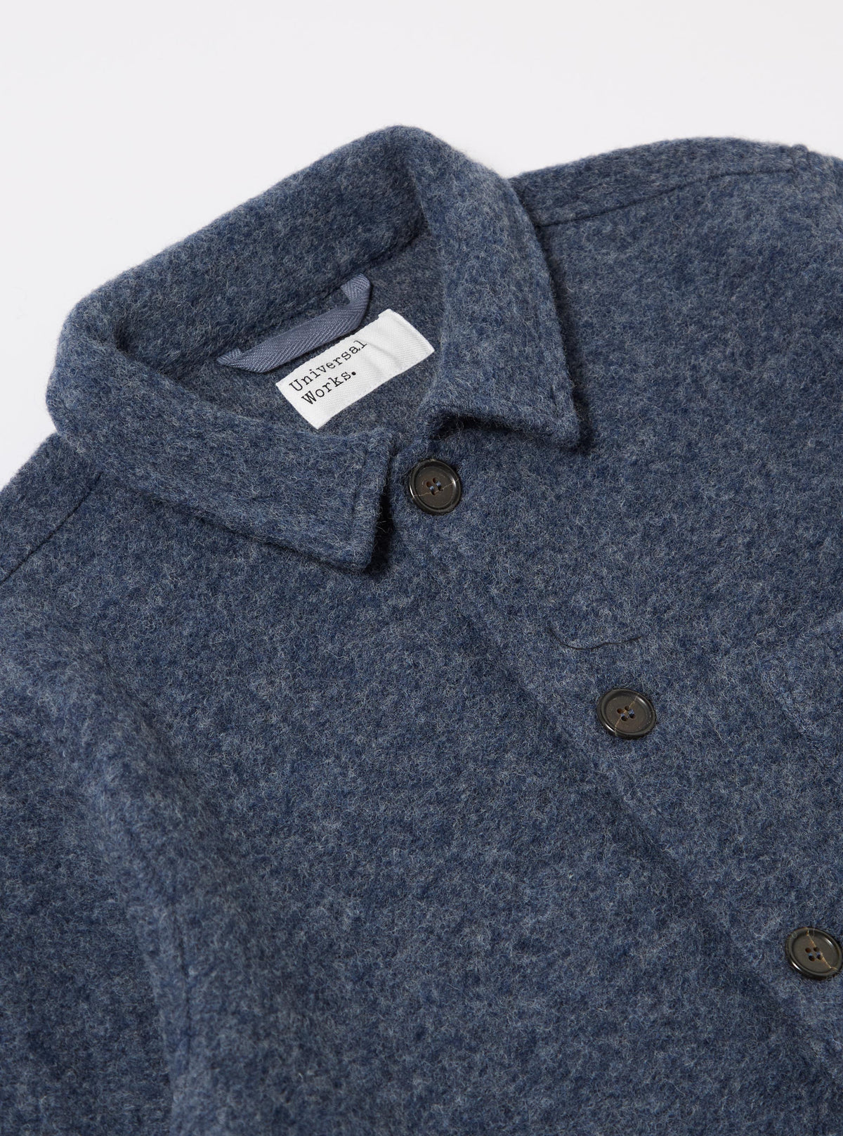 Close-up of the Slate Blue Wool Fleece Field Jacket on a white background. The jacket features dark buttons and a visible brand label.