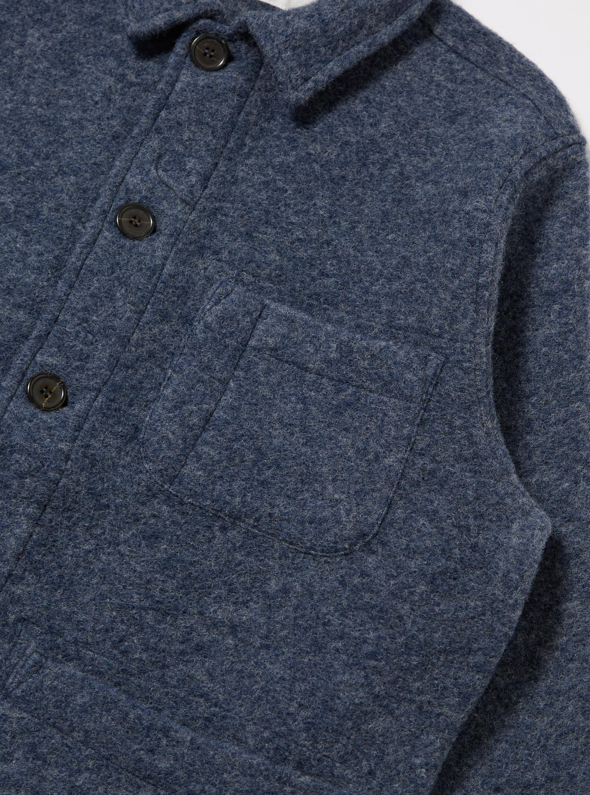 Close-up of the Slate Blue Wool Fleece Field Jacket. The jacket is made of a soft, textured wool fleece and has a relaxed fit. Shot against a white backdrop.