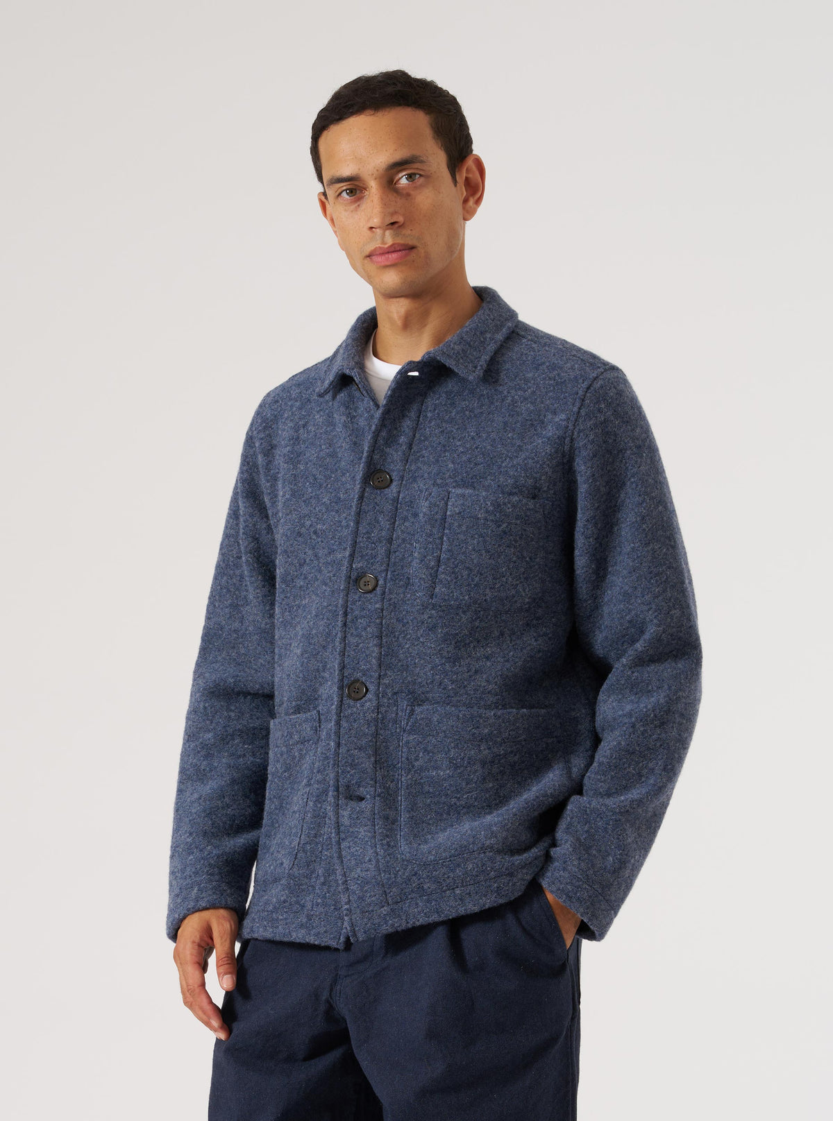 A man models the Slate Blue Wool Fleece Field Jacket in front of a white background. The jacket is buttoned and has a relaxed fit.