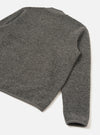 Grey marl wool fleece zip bomber, flat lay on a white surface, angled shot showing the back body and one sleeve. The boiled wool fleece has a dense, nubby texture throughout. A ribbed cuff is visible at the sleeve hem, with a matching ribbed trim at the neckline and body hem.