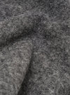 Close-up detail shot of the grey marl wool fleece fabric, showing the dense, brushed texture with fine fibres and a slightly bobbly surface. Soft folds and curves of the material fill the entire frame, highlighting the midtone charcoal colour and tactile depth of the fleece.