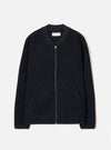 Navy wool fleece zip bomber jacket, flat lay on a light grey seamless backdrop. Textured boiled-wool-style fleece body with a smooth ribbed bomber collar in contrast navy fabric. Full-length silver zip with a small pull tab. Two welt pockets at the hip. Ribbed cuffs and hem. Universal Works woven label visible at the back neck.