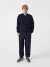 Front view of a model wearing the Navy Wool Fleece Zip Bomber Jacket in a plain studio setting. The model stands facing forward, showing the dark navy blue wool fleece jacket, front zipper, and casual style fit.