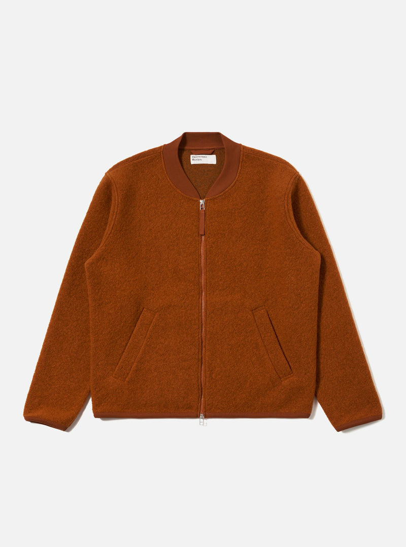 The Rust Wool Fleece Zip Bomber jacket in rust color, laid flat on a white background. The bomber has a zip front and pockets.