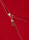 Close-up detail of the zip on a scarlet wool fleece bomber. A two-way zip with red plastic teeth and two silver metal sliders is shown partially open. A red woven zip puller tab is attached to the upper slider. The brushed wool fleece fabric texture is visible across the background.
