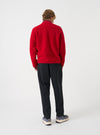 Back view of a model wearing the Scarlet Wool Fleece Zip Bomber Jacket in a studio setting. The model stands angled away, showcasing the rear cut, soft scarlet wool fleece texture, hem, and comfortable relaxed fit.