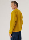 A man models the Yellow Wool Fleece Zip Bomber against a plain backdrop. The bomber is a vibrant yellow, made of wool fleece, and has a zip front. The fit is relaxed and casual.