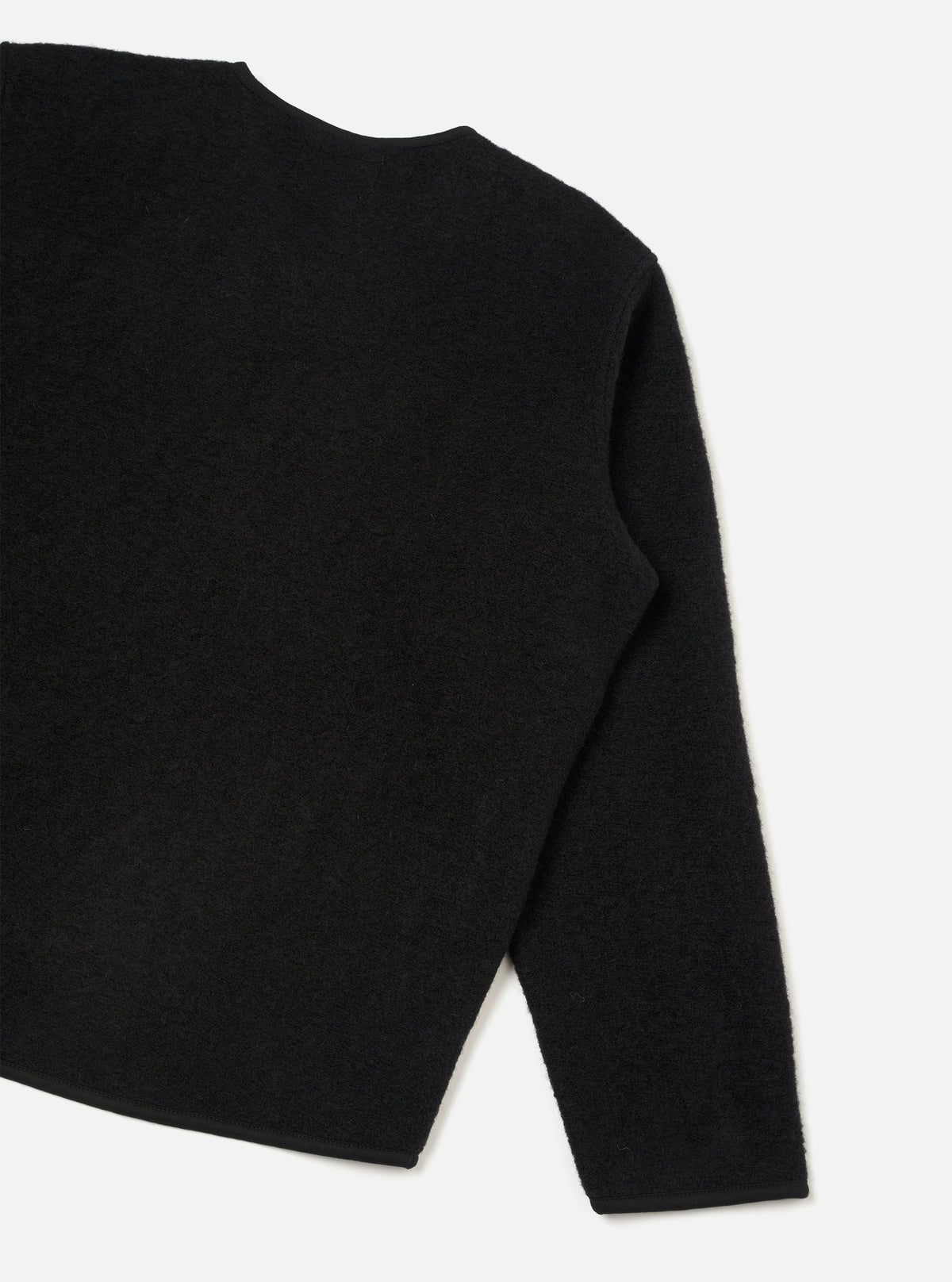 Rear view of the Black Wool Fleece Zip Liner Jacket presented flat against a white background. The image showcases the clean back construction, soft black wool fleece material, neatly finished hem, and binding details.