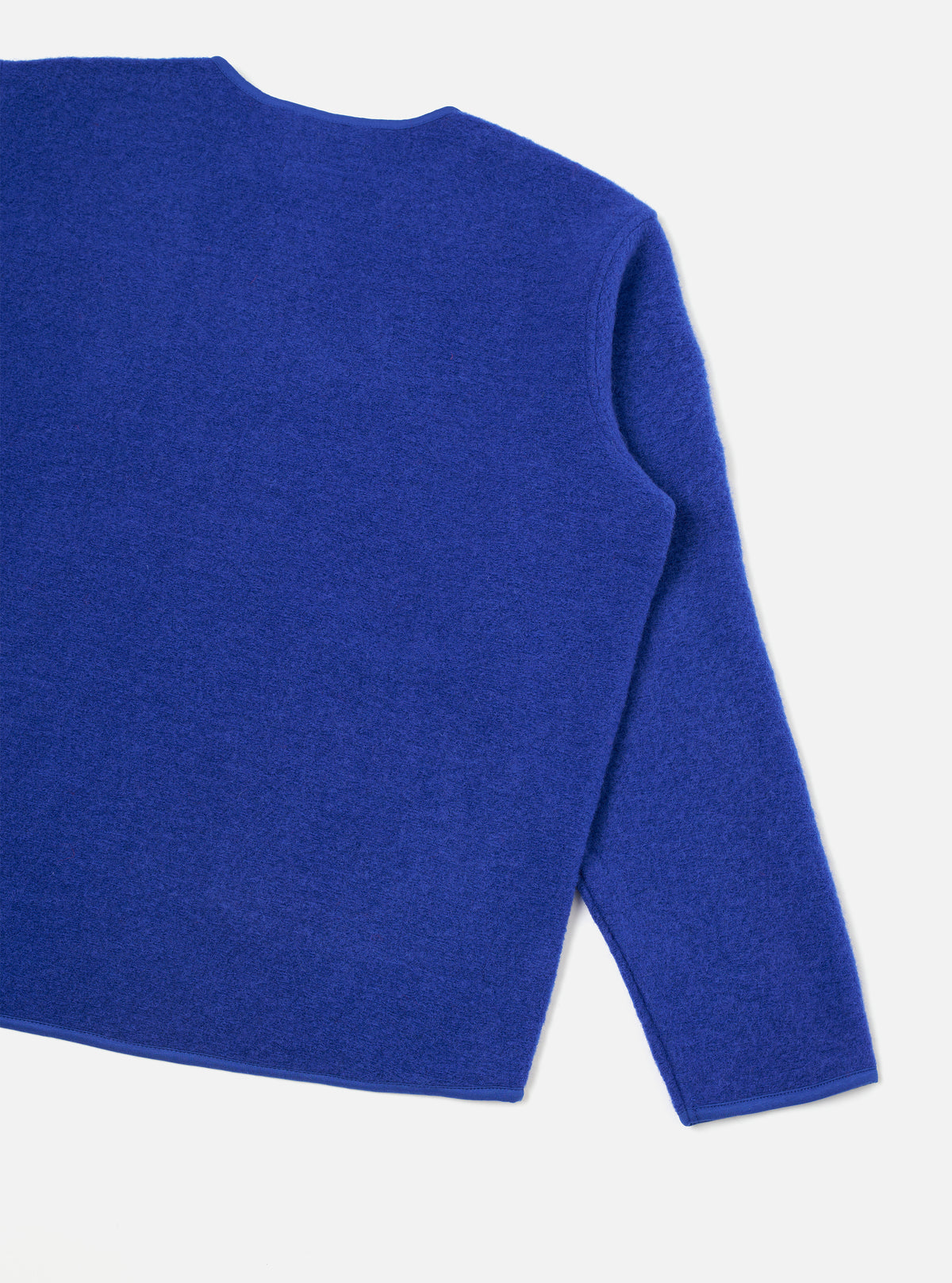 Rear view of the Blue Wool Fleece Zip Liner Jacket presented flat against a white background. The image highlights the soft blue wool fleece texture, clean back panel, stitched hemline, and simple jacket silhouette.