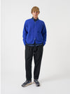 Front view of a model wearing the Blue Wool Fleece Zip Liner Jacket in a bright studio environment. The model stands facing forward, showing how the jacket fits over clothing with its open zipper and blue fleece finish.