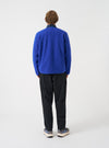 Angled back view of a model wearing the Blue Wool Fleece Zip Liner Jacket in a studio setting. Demonstrates the overall silhouette from the side and rear, emphasizing the rich blue wool fleece texture and hem length.
