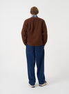 Rear view of a model wearing the Cacao Wool Fleece Zip Liner Jacket against a plain studio backdrop. Shows the back panel fit, shoulder line, and soft brown wool fleece fabric from an angled perspective.