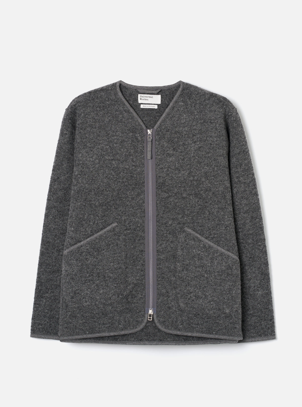 Grey marl wool fleece zip liner jacket, flat lay on a light grey seamless backdrop. Collarless V-neckline with tonal bound edges running down the full-length centre-front zip, which has silver metal pulls at top and bottom. Two large angled welt pockets at the lower front with matching bound trim. Textured boiled wool fleece fabric throughout.