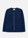 The Indigo Wool Fleece Zip Liner Jacket is laid flat on a light grey backdrop. Features a collarless V-neckline with navy binding, full-length silver zipper, two large patch pockets, and textured boiled wool fleece fabric.