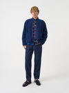 Front view of a model wearing the Indigo Wool Fleece Zip Liner Jacket in a studio environment. The model faces forward, demonstrating the rich indigo blue wool fleece texture, collarless neckline, and zip closure.