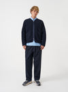 Front view of a model wearing the Navy Wool Fleece Zip Liner Jacket in a bright studio setting with a plain background. The model stands facing forward, showing the full length, zip front closure, and relaxed fit of the navy jacket.