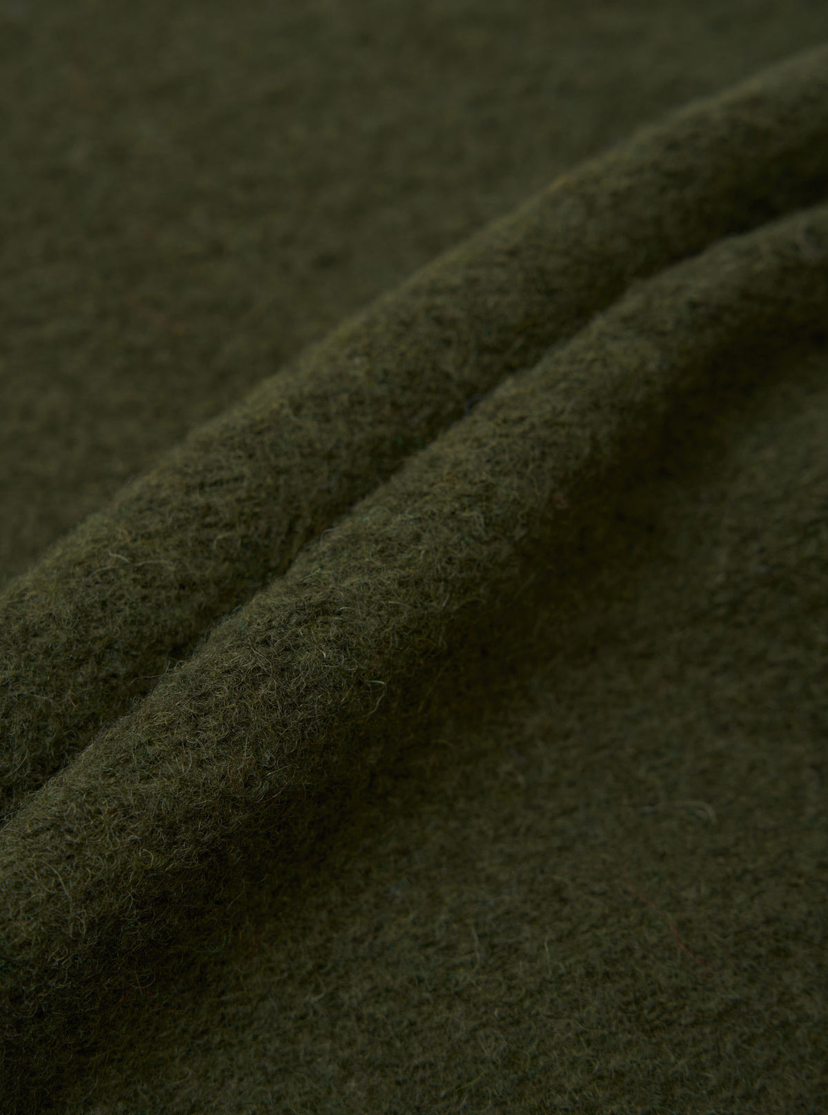Extreme close-up swatch shot revealing the detailed texture of the Olive Wool Fleece Zip Liner Jacket fabric. Highlights the soft, fuzzy olive green fibers and dense weave of the recycled wool blend material.