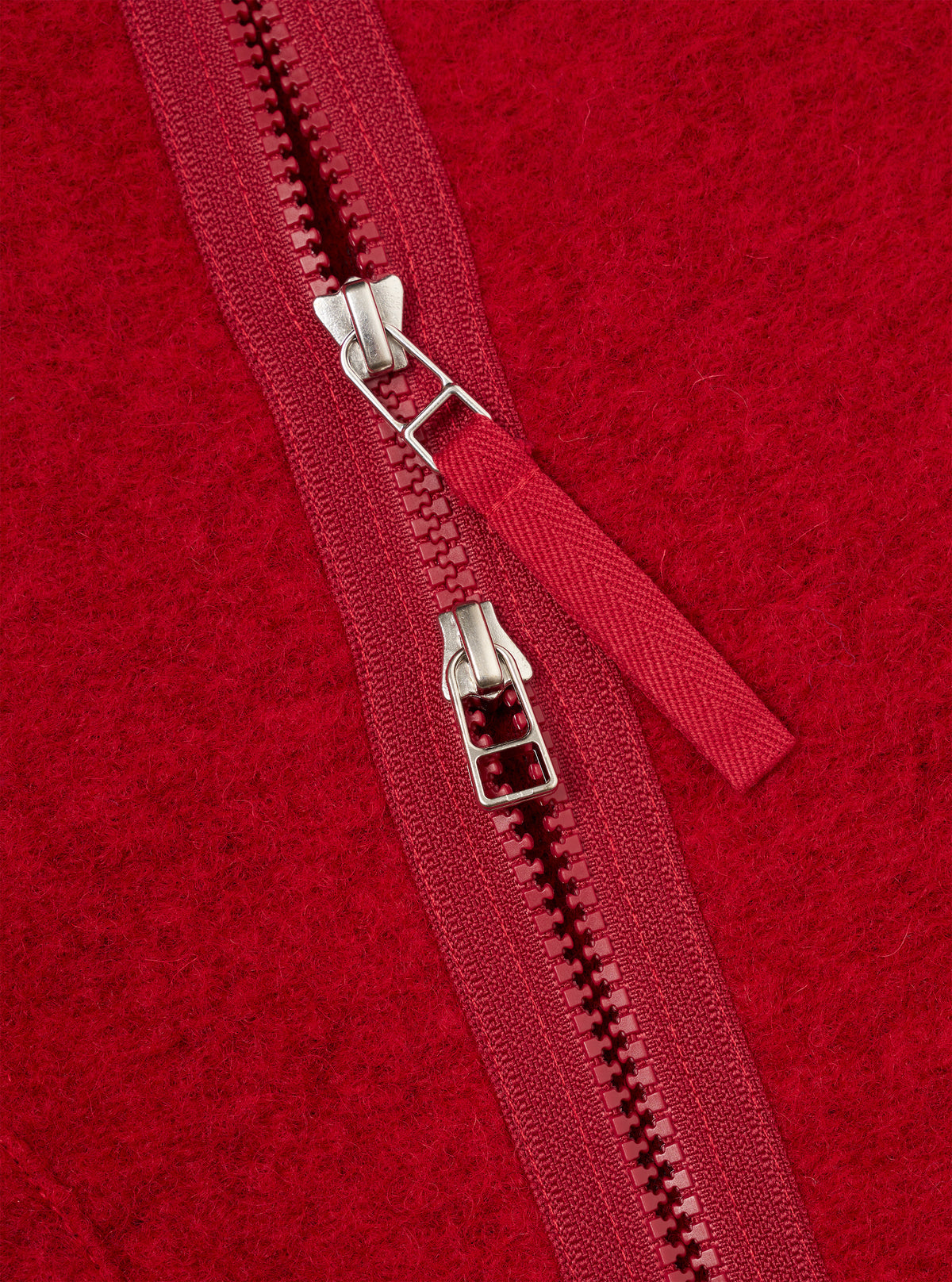 Close-up detail shot of the Scarlet Wool Fleece Zip Liner Jacket on a plain background. Focuses on the front zip hardware, bound collar, and plush, warm scarlet red wool fleece texture of the fleece material up close.