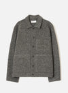 Grey marl wool fleece uniform jacket laid flat on a light grey seamless backdrop. Spread collar with a Universal Works woven label at the neckline. Five dark buttons run down the centre front placket. One chest patch pocket and two large lower patch pockets. Full-length sleeves with plain cuffs. Textured boiled wool fleece fabric throughout.