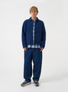 Front view of a model wearing the Indigo Wool Fleece Uniform Jacket in a plain studio setting. The model faces forward, displaying the dark indigo blue fleece texture, classic collar, button placket, and front patch pockets.