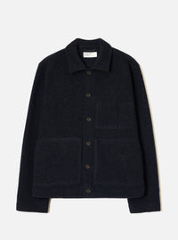 Navy wool fleece uniform jacket laid flat on a light grey seamless backdrop. Features a spread collar, five dark horn buttons down the centre front, two large patch pockets on the chest and lower front, and a ribbed hem and cuffs. The textured fleece has a dense, looped surface throughout.